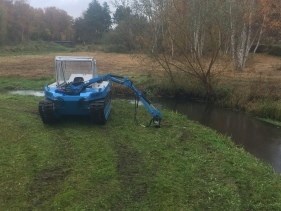 Maskinfører plejer naturgrønt område tæt på mose